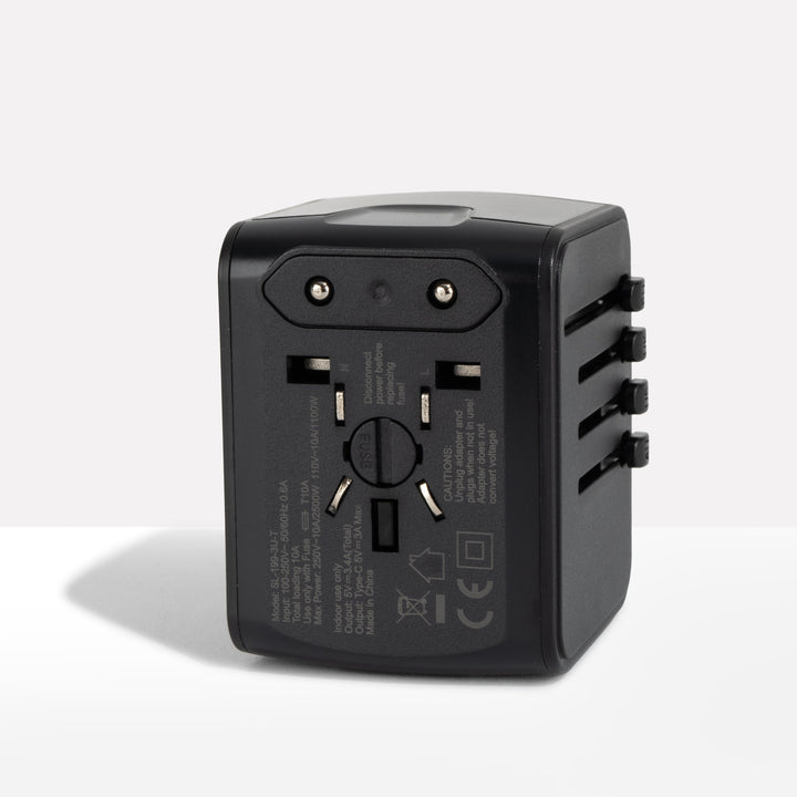 Black travel adapter seen from the back, showing the fixed two-pin plug and fuse cover 1
