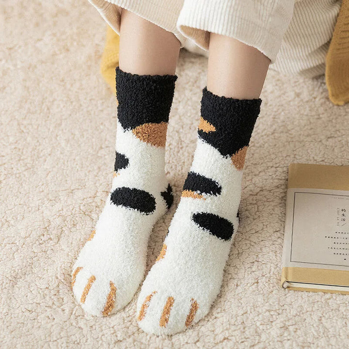 Model wearing calico fuzzy socks with black cuffs, orange and black patches, and orange claw stripes on the toes 7