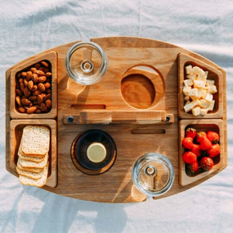 Top-down view of the wooden table with four snack trays, two wine glasses and a bottle in its holder 6