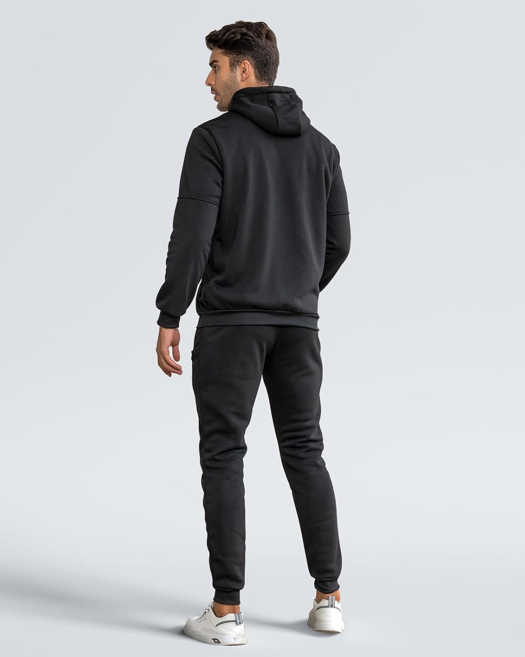 Back view of a man in a black hooded jacket and black joggers 12