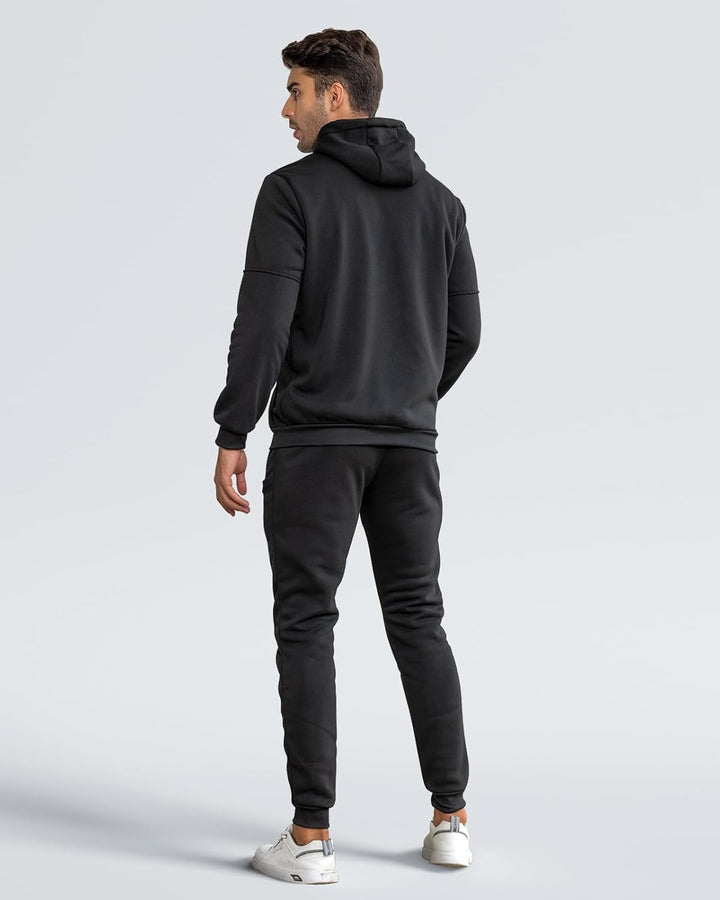 Back view of a man in a black hooded jacket and black joggers 12