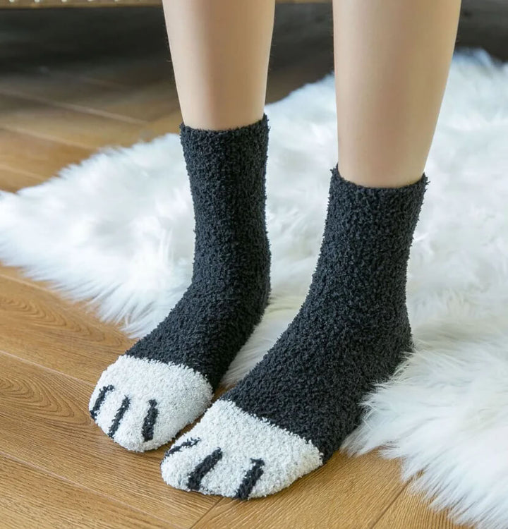 Model standing on a white fur rug in solid black fuzzy socks with white paw-pad toes 9