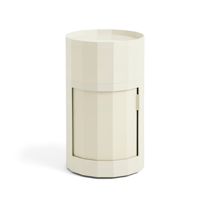 Cream-colored tall round cabinet with twelve-sided body, tray top and closed door, shown on white 2