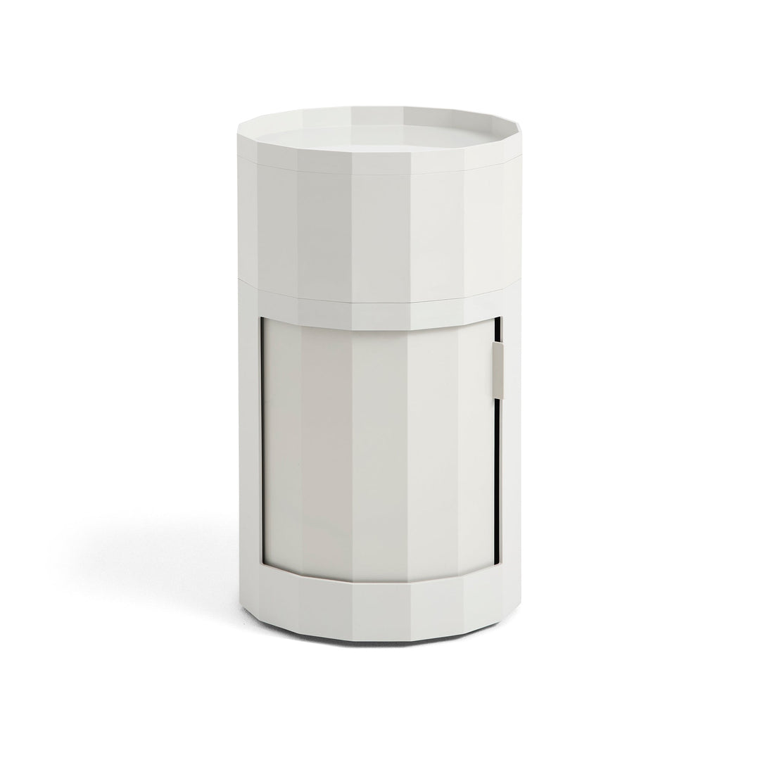 Tall round cabinet in light gray with faceted sides, tray top and closed door 5