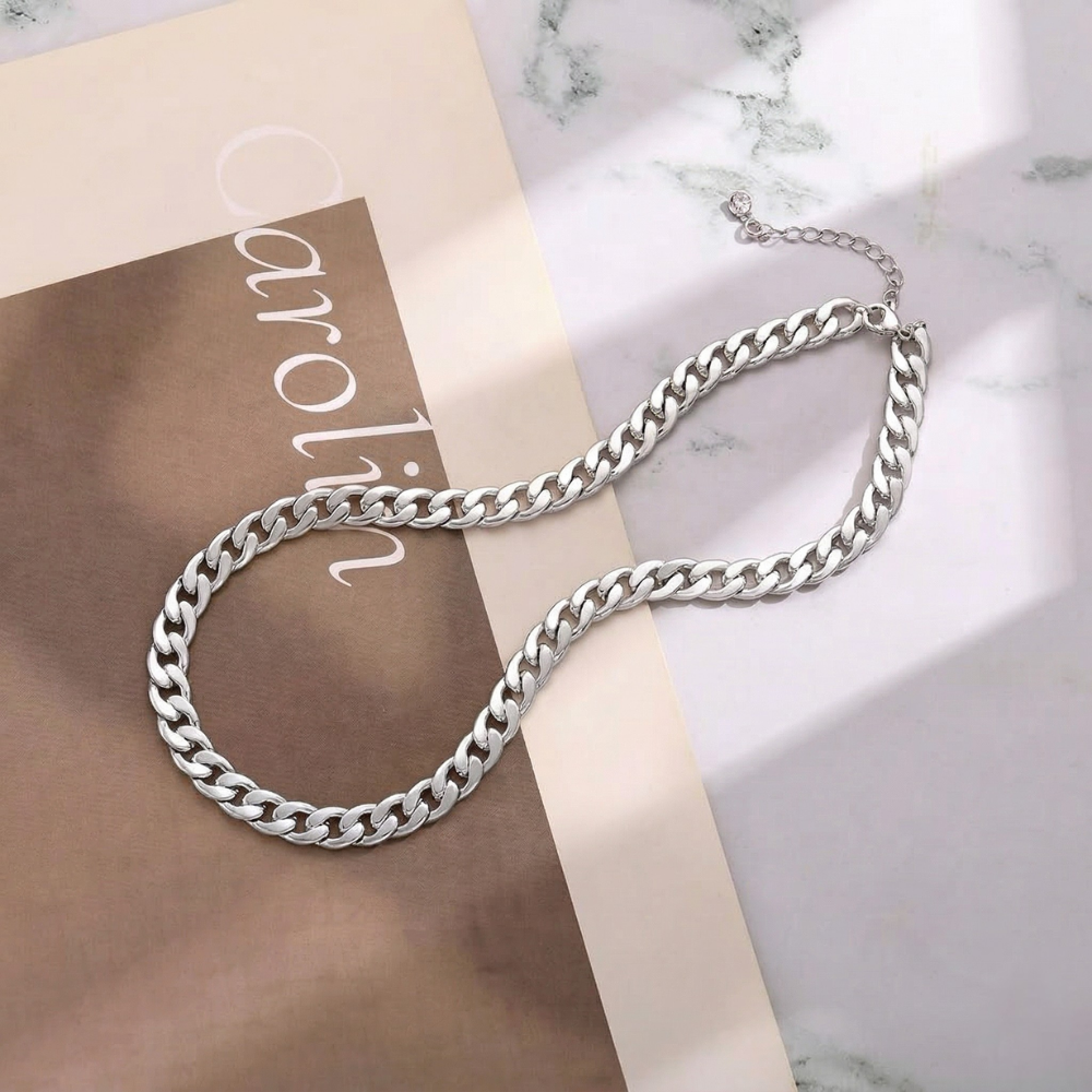 Silver-tone chain flat lay on a marble surface and beige card, with the extender chain visible 8
