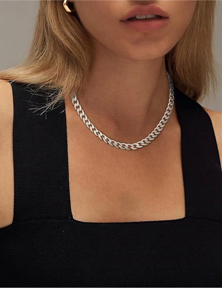 Model in a black square-neck top wearing the silver-tone chain, with a gold earring visible 9
