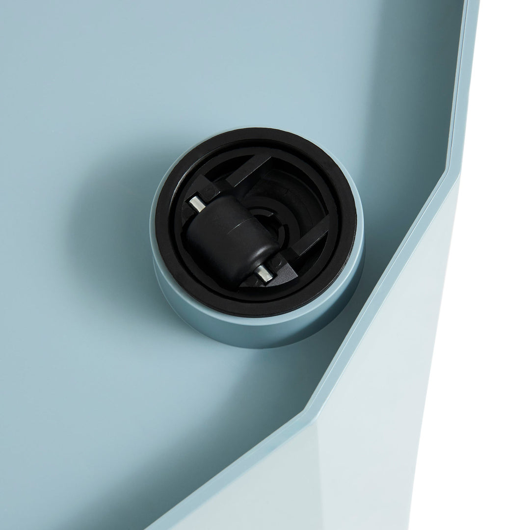Close-up of a black caster wheel set into the light blue underside of the cabinet 59