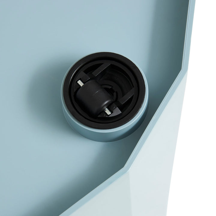 Close-up of a black caster wheel set into the light blue underside of the cabinet 59
