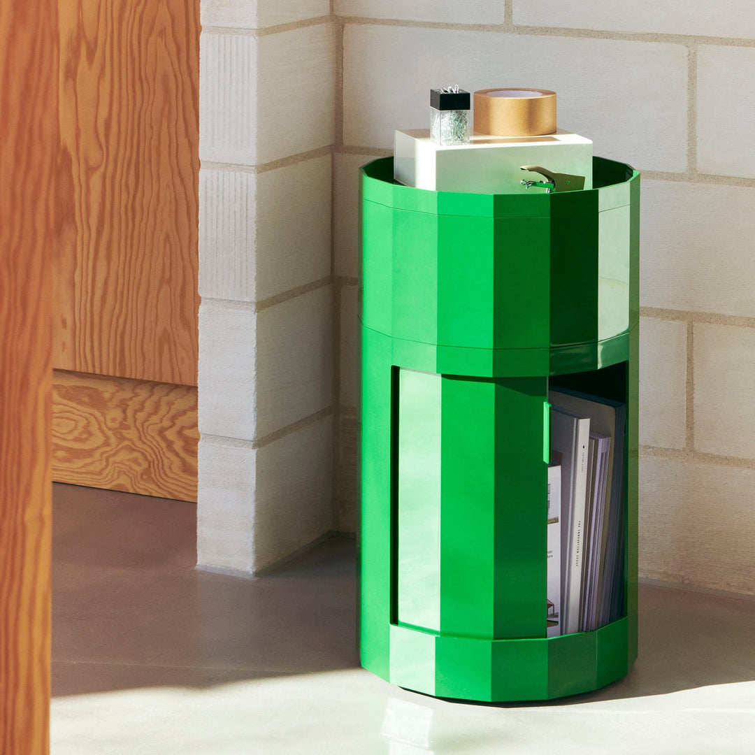 Bright green round cabinet with door ajar showing magazines, with paper clips and tape on top 7