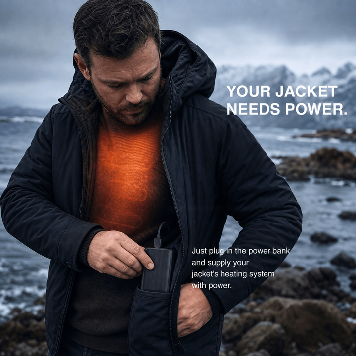 Man in a black jacket on a rocky shore tucking the battery into his pocket, orange warmth glowing on his sweater 6