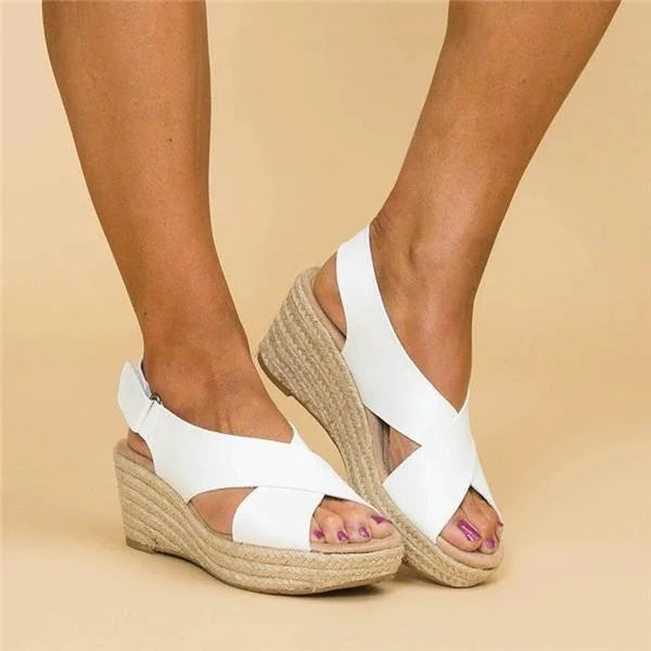 White crisscross wedge sandals seen from the side and front, with braided jute platforms 6