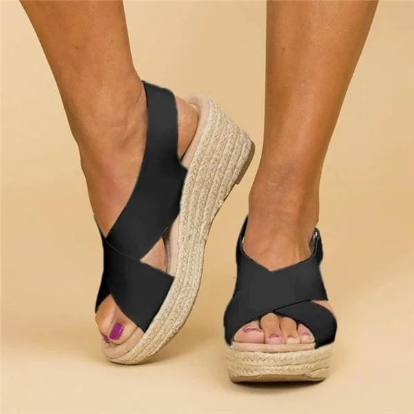 Black crisscross wedge sandals shown from the side and front, with woven jute-wrapped soles 8