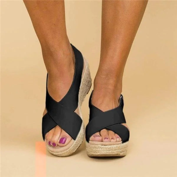 Front view of black crisscross wedge sandals showing the open toe and woven platform edge 9