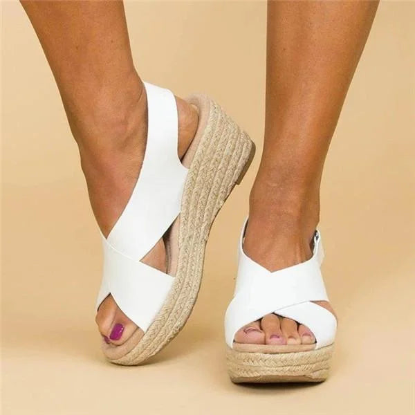 White crisscross wedge sandals shown from the side and front, with braided jute platforms 11
