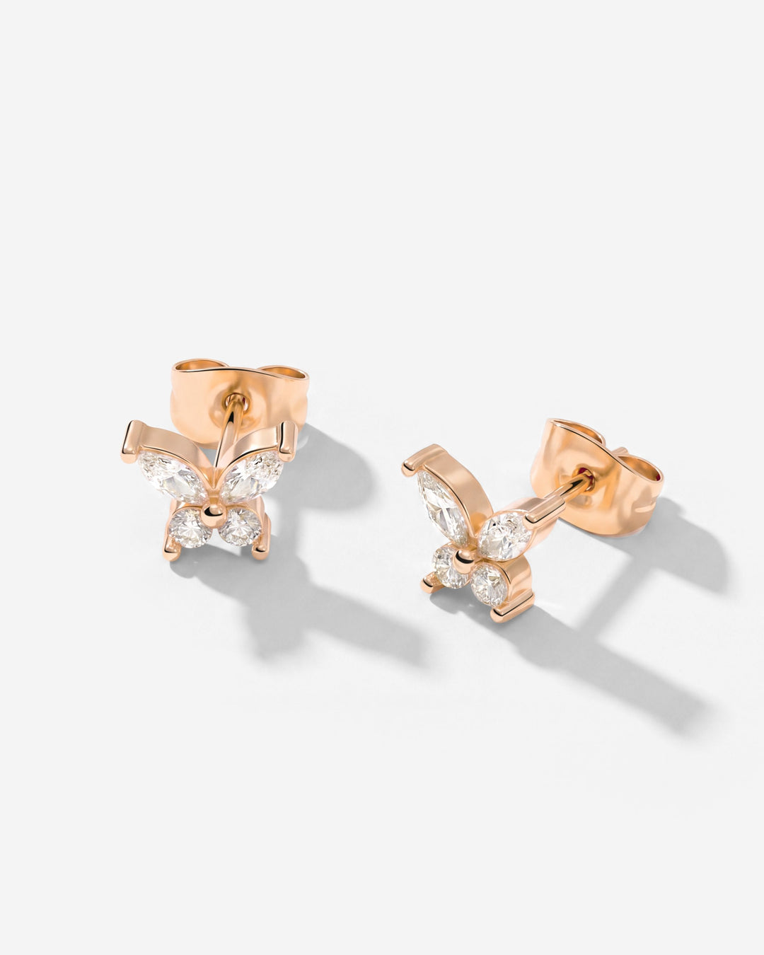 Rose gold-tone butterfly studs at an angle, showing the posts and backs, with clear stones 9