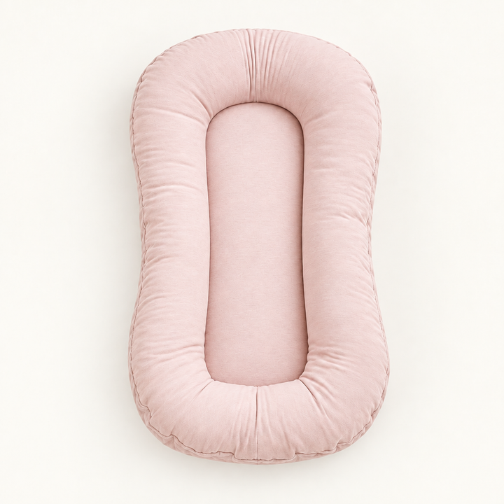 Empty blush-pink lounger with a padded rim and oval center, seen from above 10