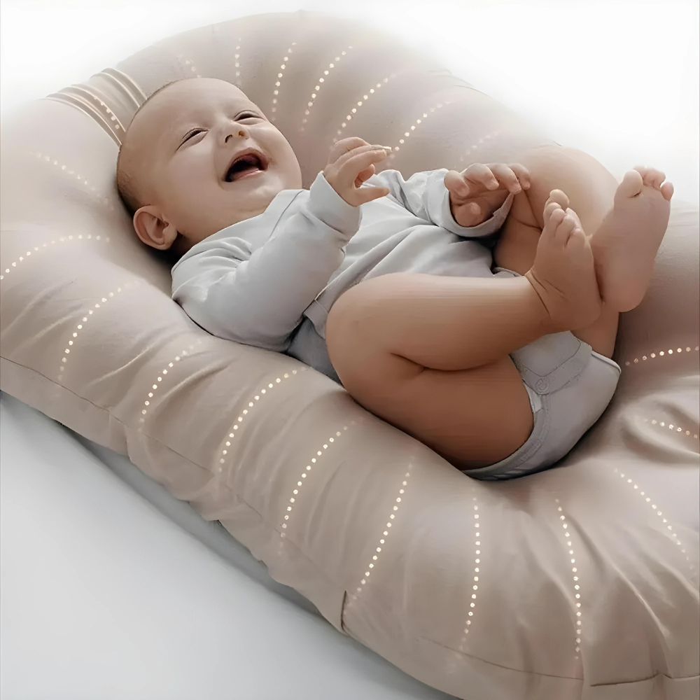 Close-up of a laughing baby kicking on a beige lounger with dotted stitched lines 2