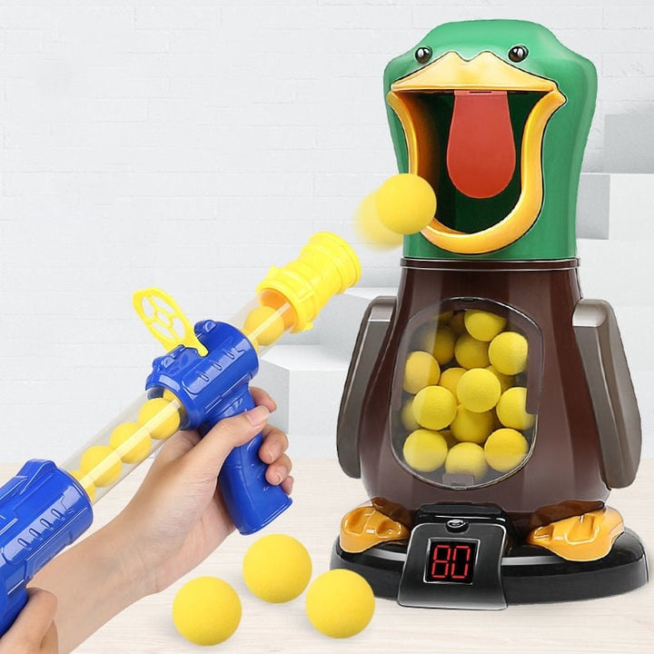 A hand fires a foam ball from a blaster into the open beak of the duck target 2