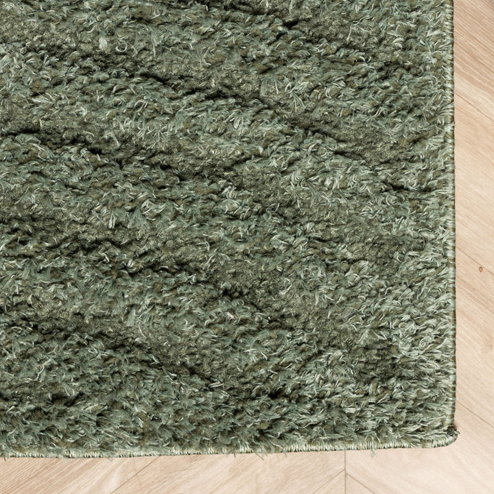 Rug corner close-up showing the stitched edge and dense pile against light herringbone flooring 5