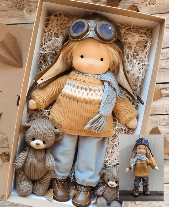 Aviator doll in knit sweater and scarf lying in an open gift box beside a knitted bear 2