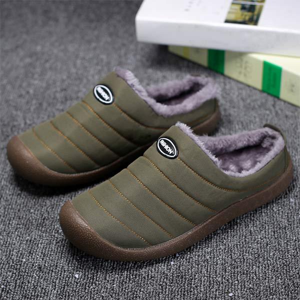 Olive green quilted slippers with plush gray lining, shown from above on a gray carpet near books 3