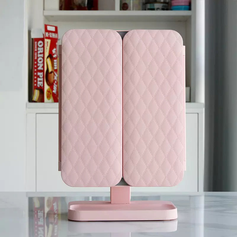Back of the pink mirror with its two folded panels in diamond-quilted leather, standing on a tray base 2