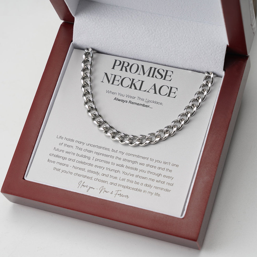 Silver curb link chain resting on a message card inside an open red wooden gift box 1