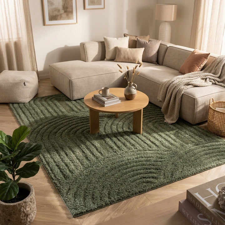 Green arch-patterned rug under a round wooden coffee table in front of a beige sectional sofa 1