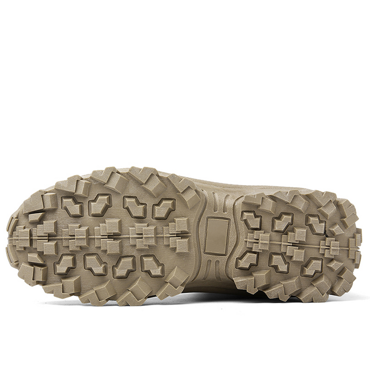 Close-up of a tan boot's outsole, showing the blocky lugs and central rectangular plate 13