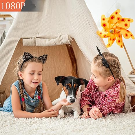 Two girls and a small dog playing on a fluffy rug in front of a teepee 2