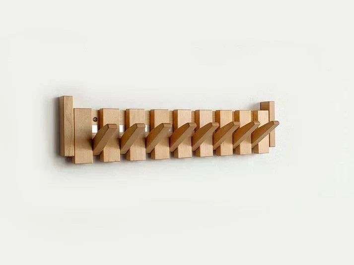 Light natural wood rack with eight hooks folded out diagonally on a pale wall 7