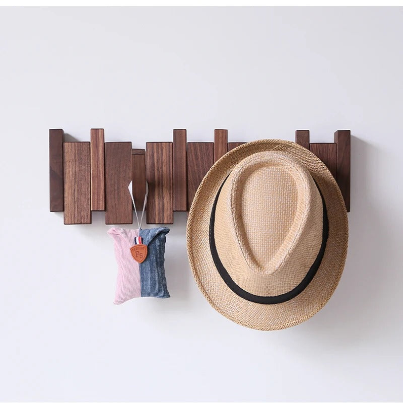 Dark walnut rack on a plain wall with a straw fedora and a small pink and blue pouch hanging 3