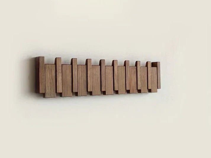 Dark wooden rack with all hooks folded flat, forming an uneven slatted pattern on the wall 9